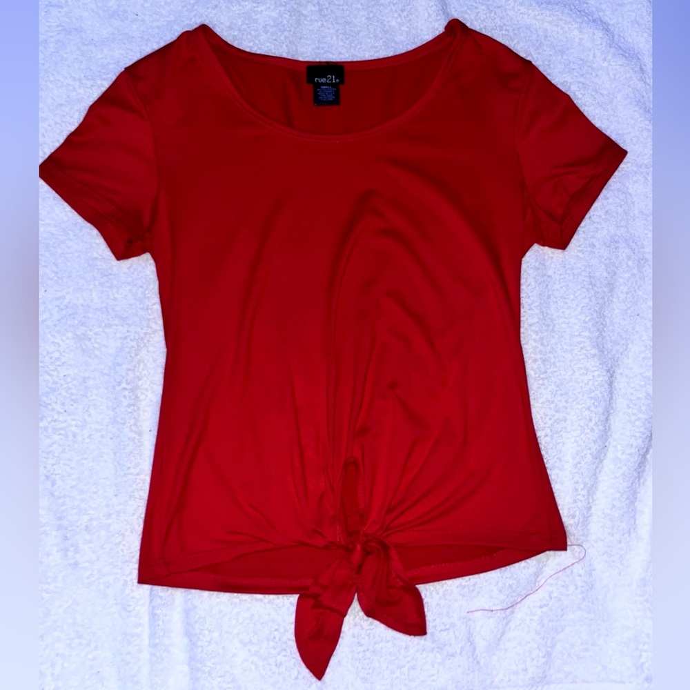 Red silky T-shirt with tie at the bottom.
